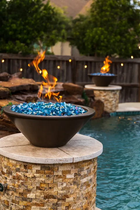 Poolside fire bowls on stone columns