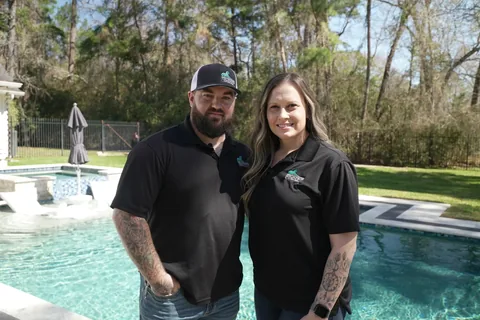 Kyle and Angela Thompson standing beside a custom pool