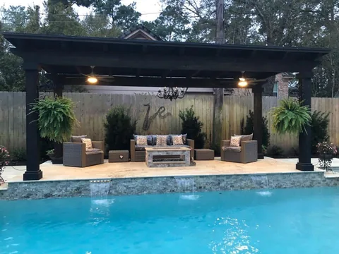 Poolside pergola with outdoor seating and a fire table