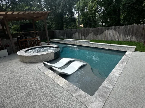 Custom pool with a raised spa and in-water lounge chairs