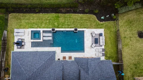 Overhead view of a pool, raised spa, and surrounding patio