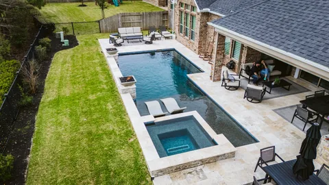 Overhead view of a custom pool and spa beside a covered patio